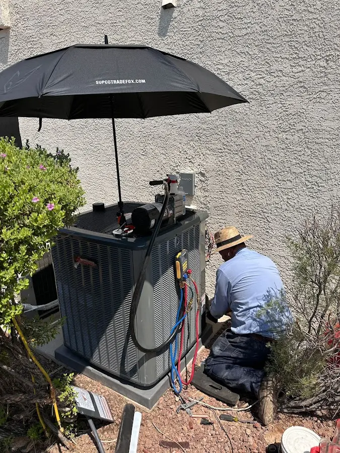 HVAC technician performing outdoor AC maintenance in Casas Adobes