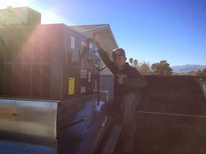 HVAC technician performing AC Tune-Up on a rooftop unit in Casas Adobes